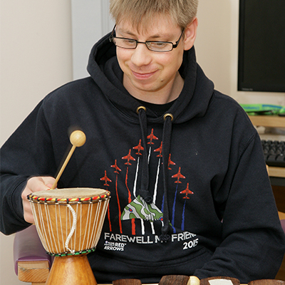 Young man playing small drum