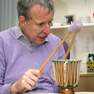 Older gentleman playing small drum